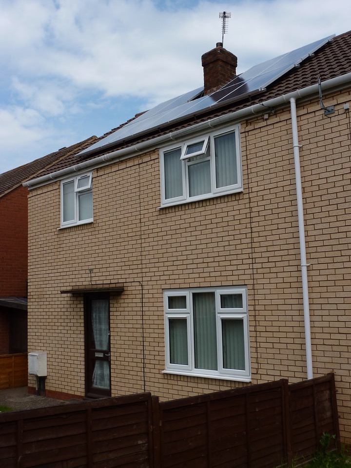 Solar panels fitted to the pitched roof of a brick semi detached house in England